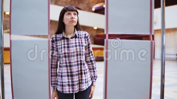 一位年轻女子在画廊里检查展览视频的预览图
