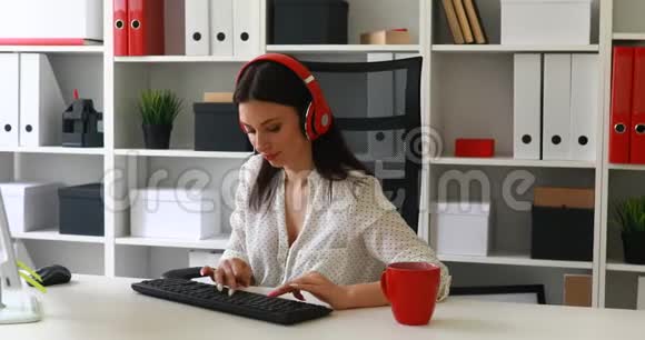 女商人听音乐用键盘打字视频的预览图