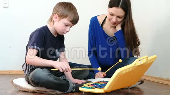 演奏音乐乐器老师教男孩玩木琴视频的预览图