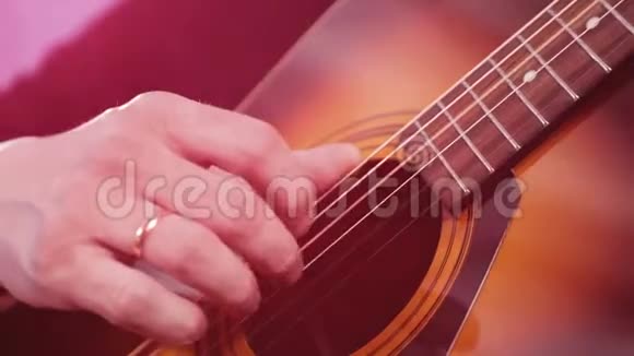 男人弹声吉他弹吉他琴弦的手的特写视频的预览图
