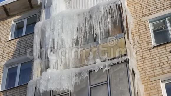冬天一栋公寓楼的屋顶和阳台上挂着的冰柱视频的预览图