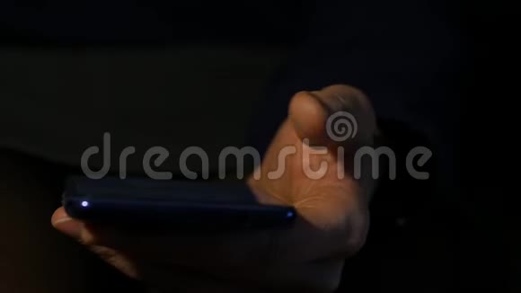 关闭女性她的手指在夜间使用智能手机女孩在手机上浏览互联网慢动作视频的预览图