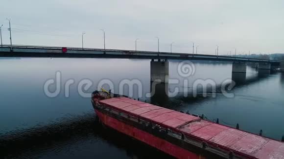 在宽阔的河桥下的现代货船视频的预览图