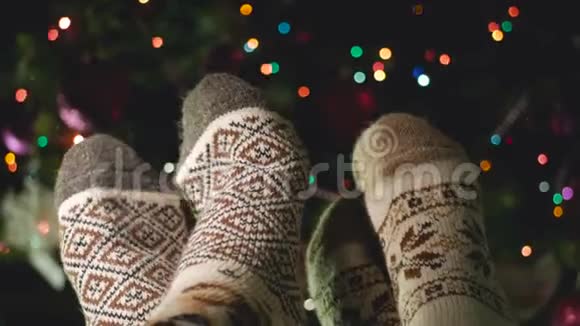 在一棵美丽的圣诞树旁边两条腿穿着温暖的羊毛袜子视频的预览图