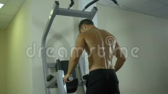 一个身体赤裸的年轻运动员在健身房里从事体力劳动用手摇动肌肉视频的预览图