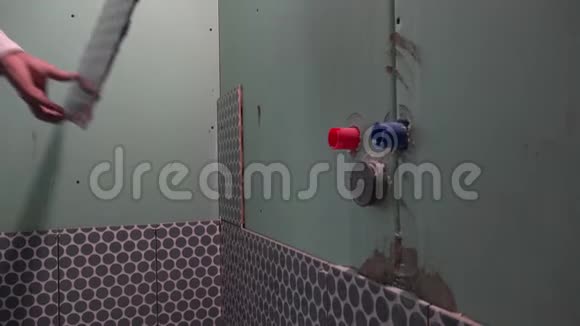 熟练工人安装浴室墙上的地砖视频的预览图