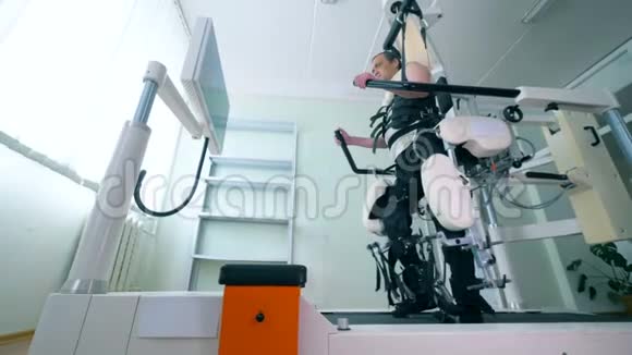 医疗机器人一名男性病人在行走模拟器上运动的医疗训练室视频的预览图