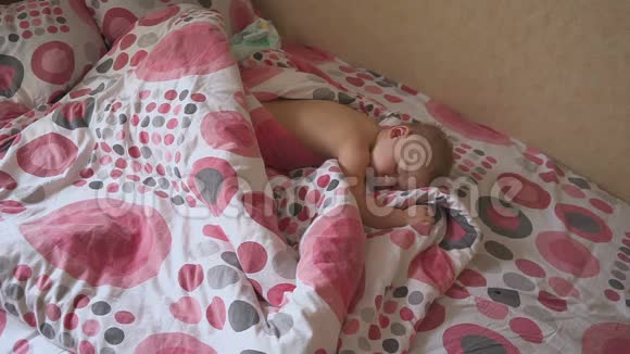 可爱的婴儿睡在他的床上在家里的房间睡眠婴儿概念1岁的男婴睡在家里视频的预览图