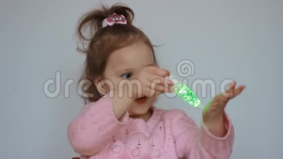 一个可爱的孩子玩手电筒看着五彩的光芒和光一个美丽的女孩抱着视频的预览图