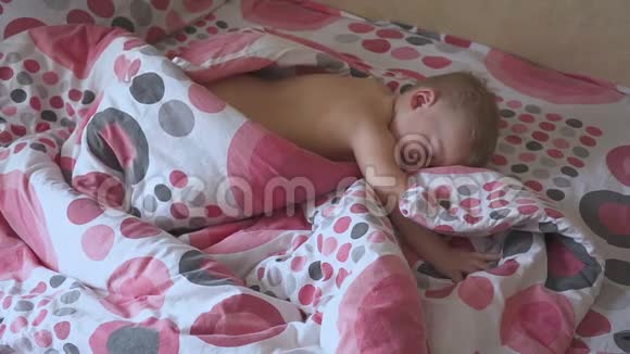 可爱的婴儿睡在他的床上在家里的房间睡眠婴儿概念1岁的男婴睡在家里视频的预览图