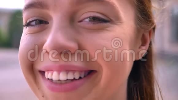 年轻的姜女在镜头前微笑的近镜头幸福快乐的女性的肖像背景街道视频的预览图