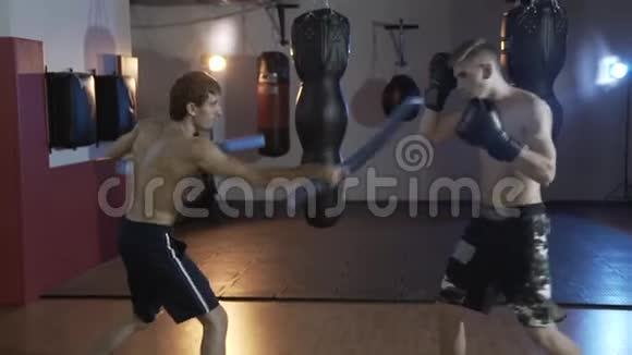 从教练后面看拳击手的运动员在打前进行拳打脚踢手套拳击训练这就是视频的预览图