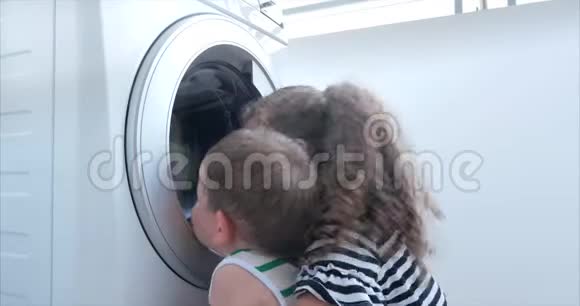可爱的孩子们在洗衣机里看气缸旋转机概念洗衣机工业视频的预览图