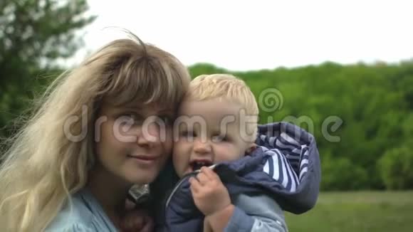 快乐妈妈和她可爱的小男孩在公园散步视频的预览图