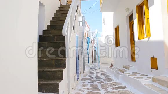 两个穿蓝色裙子的女孩在户外玩得很开心典型的希腊传统村落有白色墙壁和视频的预览图