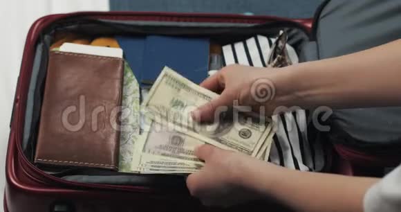 旅行的钱女人在手提箱背景上数着美元钞票女孩要去旅行了手提箱视频的预览图