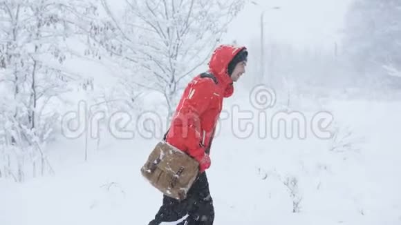 一位男性旅行者在大雪中走在树林里穿过雪地视频的预览图