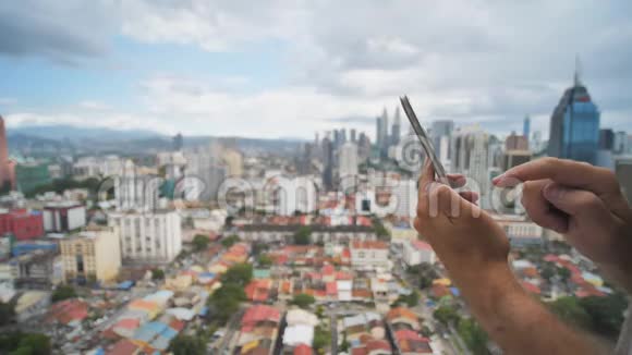 这家伙正在模糊的背景下使用智能手机吉隆坡把手和电话合上马来西亚视频的预览图