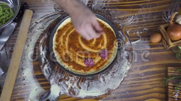 顶视图厨师在比萨店厨房用香肠意大利香肠做比萨木桌上放面粉披萨准备视频的预览图