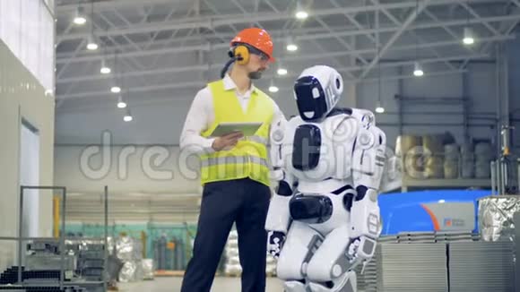 男工打开机器人然后在工厂里迎接它4K视频的预览图