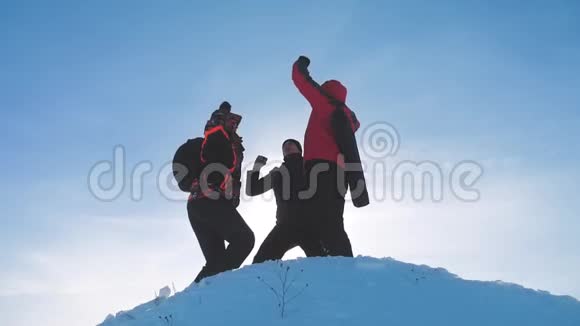 团队合作的赢家团队旅游徒步旅行者成功赢得冬天到达山顶剪影阳光视频的预览图