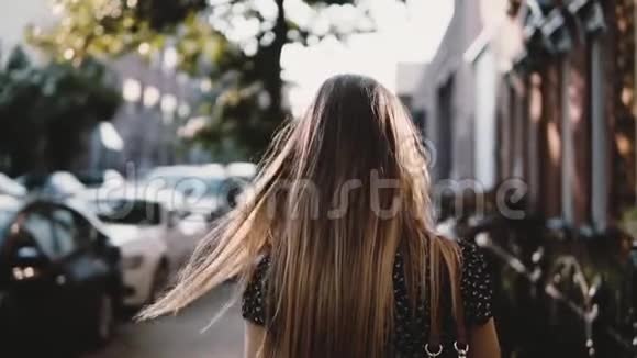后景快乐的欧洲女自由职业者头发随风飘扬走在城市街道上动作缓慢视频的预览图