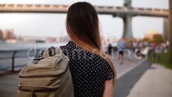 镜头跟随年轻的女游客带着墨镜的背包沿着阳光明媚的纽约布鲁克林公园慢走视频的预览图