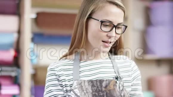 一个年轻的女人正在花店里工作她的笔记本电脑和电话她的工作包括花卉护理和花卉处理视频的预览图