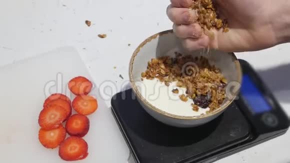 提供早餐碗里的白色酸奶把麦片洒在酸奶上视频的预览图