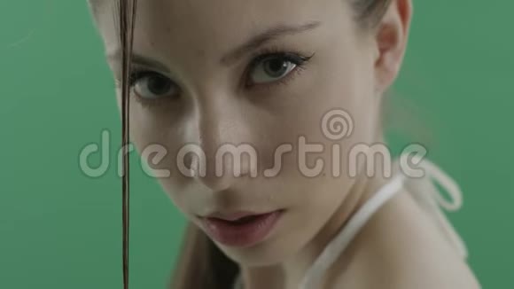 一个年轻漂亮的女人穿着一身湿发脸上带着绿色的底色视频的预览图