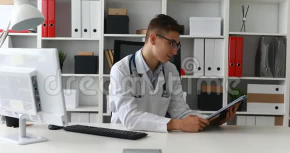 年轻的医生拿着纸对着镜头微笑视频的预览图