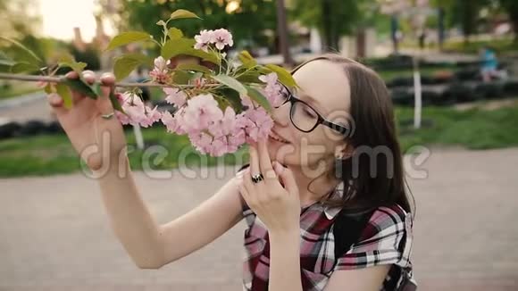 有樱花树花的快乐女孩专心面对春天的概念慢动作视频的预览图
