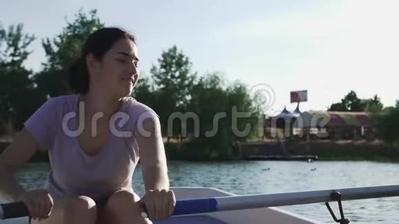 美丽的女孩笑着在船上划桨视频的预览图