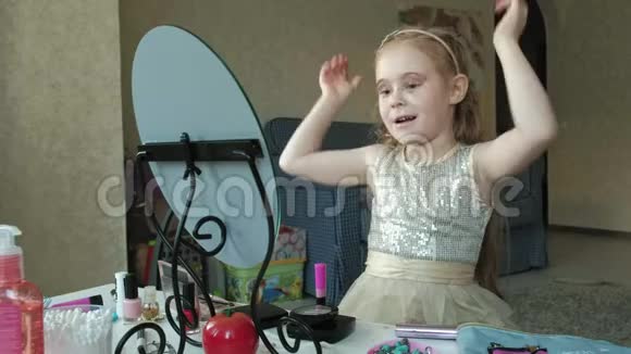 一个红头发的小女孩头上戴着一个边框试穿配饰照镜子化妆脸时尚视频的预览图