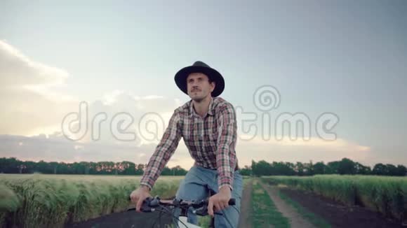 男子骑自行车在田野上视频的预览图