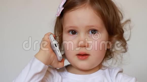 有趣的孩子在智能手机特写上讲话宝贝女孩在手机上说话视频的预览图