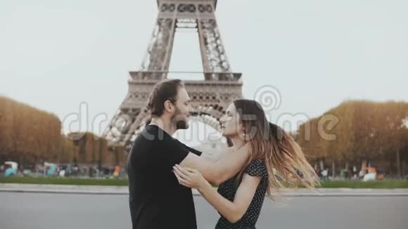 年轻快乐的一对夫妇在法国巴黎埃菲尔铁塔附近散步接吻在蜜月旅行的男人和女人视频的预览图