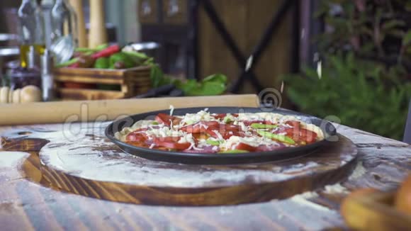 在生披萨上倒入奶酪在披萨厨房准备用奶酪西红柿和披萨做披萨视频的预览图