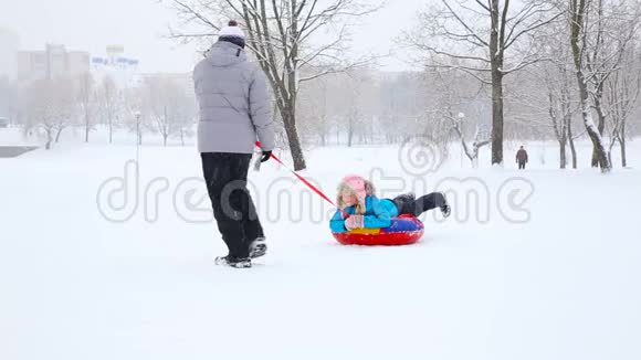 冬天在一个白雪覆盖的公园里孩子们和一只狗玩得很开心视频的预览图