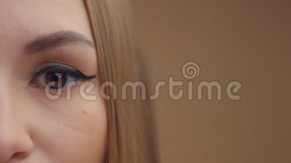 女人眼睛看着相机一半的面部特写视频的预览图
