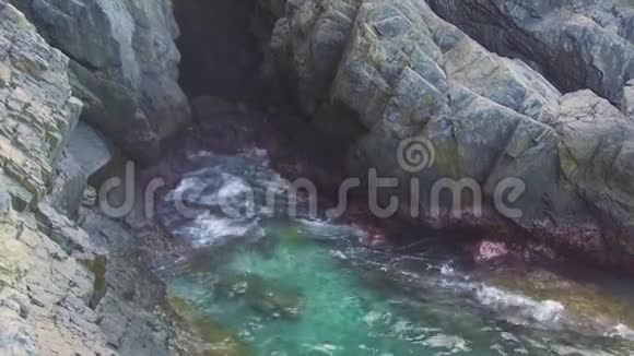 碧海的水波溅落在石崖上波浪在悬崖上破碎蓝色海水和大石头视频的预览图