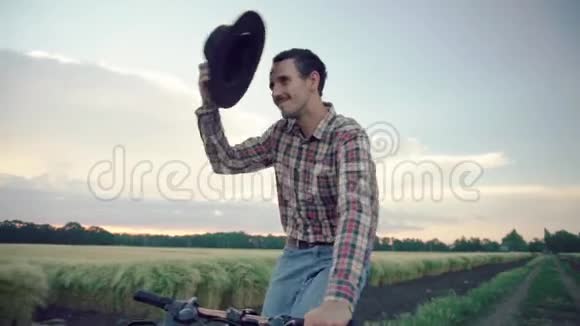 男子骑自行车在田野上视频的预览图