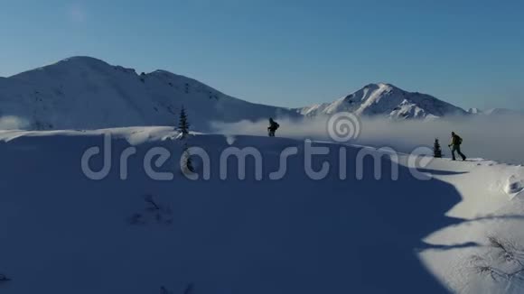 从无人驾驶飞机出发一对自由滑雪者在雪山上行滑雪视频的预览图