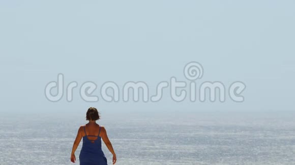 年轻的女人俯瞰大海张开双臂拥抱大自然视频的预览图