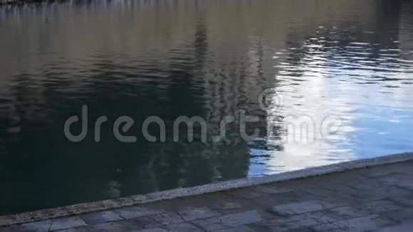 靠近一条有喷泉的河流附近的灰色人行道库存在河的暗水附近有一条小径视频的预览图