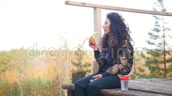 一个女人坐在高空平台上吃香蕉视频的预览图