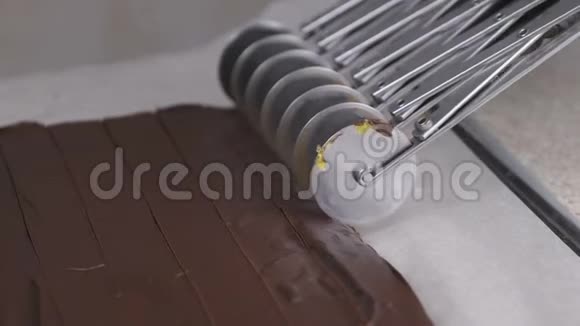 用轮式不锈钢切割刀切割杏籽巧克力蜜饯的填充物视频的预览图