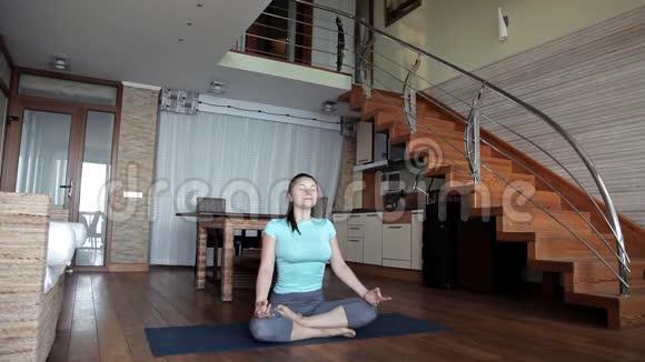 年轻的运动女性在家工作在客厅地板上做健身运动通过在线个人训练视频的预览图