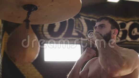 有胡子的拳击手用速度包训练年轻拳击手练习拳击视频的预览图