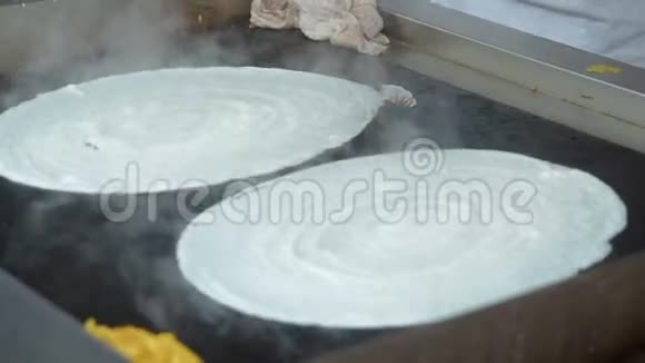印度早餐用扁豆和多沙米饭做成的薄饼特写在户外烹饪印度街头快餐厨师视频的预览图